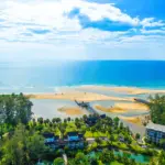 Aerial view of the quiet Natai Beach coastline and resort grounds in Phang Nga